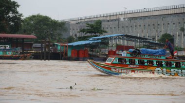 Palembang, Endonezya - 30 Mayıs 2024: Musi Nehri 'nde mal taşıyan tekneler. Güney Sumatra, Endonezya 'daki Palembang şehrindeki ünlü nehir..