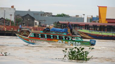 Palembang, Endonezya - 30 Mayıs 2024: Musi Nehri 'nde mal taşıyan tekneler. Güney Sumatra, Endonezya 'daki Palembang şehrindeki ünlü nehir..