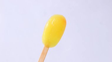 Almost finished ice cream sticks with yellow color and fruit flavor on a white background clipart