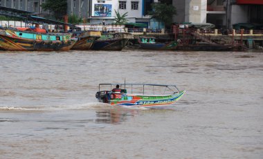 boats as transportation on the Musi River. famous river in the city of palembang, south sumatra, indonesia. clipart