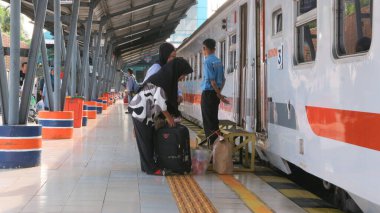  Hafta sonu Palembang Kertapati Tren İstasyonu 'nun önünde yürüyen yolcular.