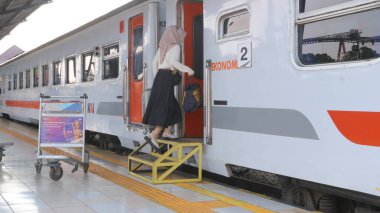  Passengers walking outside Palembang's Kertapati Station of the Train at the weekend. clipart