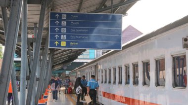  Passengers walking outside Palembang's Kertapati Station of the Train at the weekend. clipart