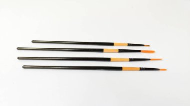 Beyaz arkaplanda boyalı farklı fırçalar