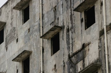 Caddenin ortasında terk edilmiş bir bina.