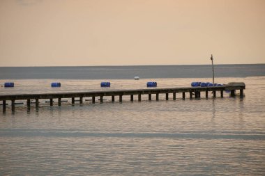 Ahşap sütunlarla iskeleden iskeleye kadar uzun ahşap iskele. Rıhtımda arka planda ufuk çizgisi olan özel bir rıhtımın havadan görüntüsü..
