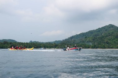 Geleneksel mavi ahşap tekne yaz tatilinde Pahawang 'daki tatil yerine gidiyor.