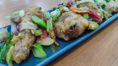 Mavi seramik tabakta tuzlanmış yumurtalı kızarmış tavuk ve beyaz izole edilmiş. Seçici odak.