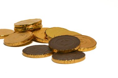 Çikolata sikkeleri. Kahverengi arka planda kahverengi madeni para. Bozuk paralar farklı pozisyonlarda üst üste istiflenir. Bir avuç bozuk para..