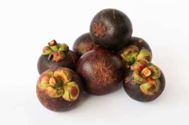 Manggis (Garcinia mangostana L), taze olgun mangosteen meyveleri ve kalın mor deri ve beyaz eti gösteren kesit.