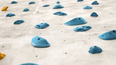 Tırmanma duvarının soyut renginde parmak ve el ele tutuşmalar açık spor salonu macera parkında çeşitli renkli tutamlar..