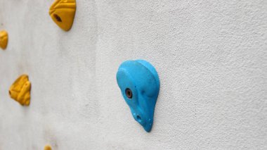 Tırmanma duvarının soyut renginde parmak ve el ele tutuşmalar açık spor salonu macera parkında çeşitli renkli tutamlar..