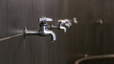 Su dolabındaki musluk. Seçici odaklanma. Damlayan musluktan bir damla su damlıyor.