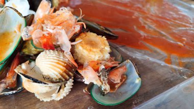 Baharatlı soslu çeşitli deniz ürünlerinin görüntülerini kapat. Midye, karides, yeşil midye, mısır, mürekkep balığı ve yengeç.