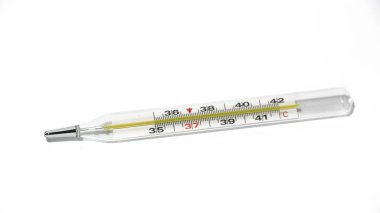Beyaz yüzeyde klinik termometrenin yakın çekim görüntüsü. Tıbbi cam termometre vücut sıcaklığının 37 derece olduğunu gösteriyor. Beyaz arkaplanda cıva termometresi.