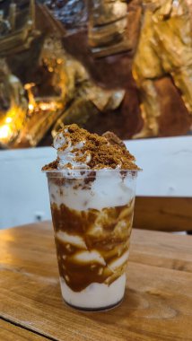 Lotus Biscoff meyveli milkshake, çikolata, krem şanti ve bardakta servis edilen saman sağlıklı içeceğin arka planında izole edilmiş.