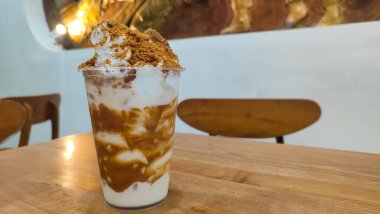 Lotus Biscoff meyveli milkshake, çikolata, krem şanti ve bardakta servis edilen saman sağlıklı içeceğin arka planında izole edilmiş.