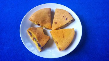 Taze peynirli kek. İçi çikolata dolu. Beyaz tabakta dilimler.