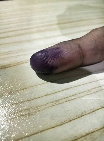 Masadaki oylamadan sonra serçe parmağı ya da Kelingking el hareketini kapat. Portre 2024 veya Pemilu Endonezya Seçimleri. Mor mürekkep batırılmış parmak.