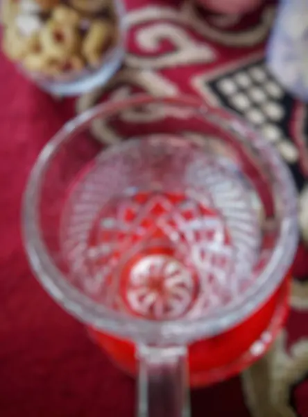 stock image Close-up of a small clear glass drinking cup, laid flat. Blur, defocused