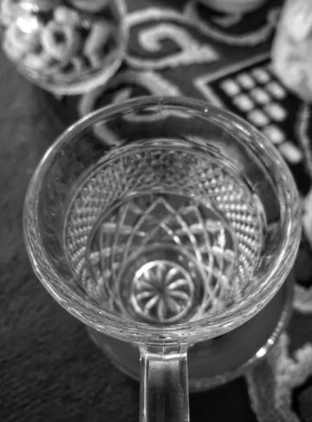 stock image Black and white. Close-up of small clear glass drinking cup, flat lying.