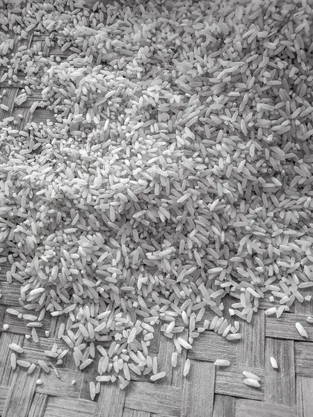 Siyah ve beyaz, pirinç tepsisindeki beyaz pirinç tanelerine yakın çekim ya da Endonezya 'dan gelen tampah. Pirinç dünyada en yaygın olarak yetişen tropikal tahıldır. Sonuç olarak Oryza sativa bitkisi.