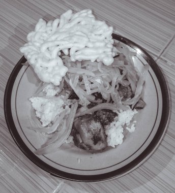 Siyah beyaz, Endonezya ev yemeklerinden oluşan lezzetli bir tabak. İçinde beyaz pirinç, çiğ sebze, beyaz kraker ve tavuk kebabı var. Arka planda fayanslı bir zemin görebilirsiniz..