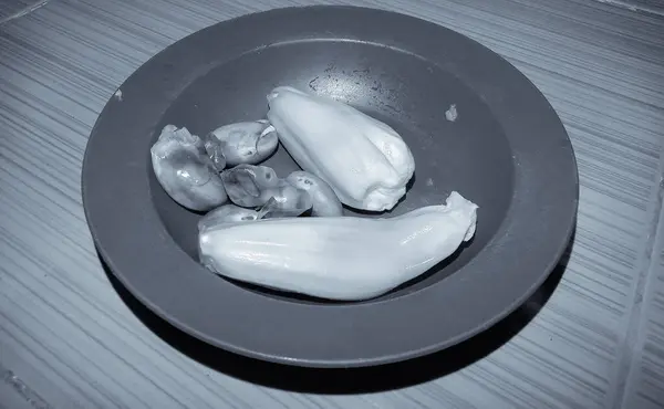 Manzara fotoğrafı mor plastik bir tabakta taze meyveler gösteriyor. Tatlı ve vitamin açısından zengindir, siyah ve beyaz mahsuldür.