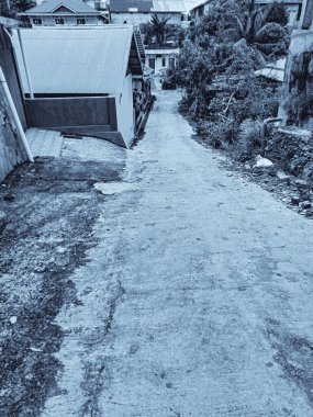 Sadece bir arabaya sığabilen pansiyonlara, barınaklara giden çimento yolları daraltır. Dikey, siyah ve beyaz dar sokaklar.