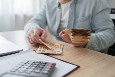 tasarruf, finans, Ekonomi ve ev concept - adam para sayma ve notlar evde hesap makinesi ile yakın çekim