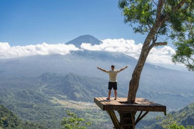 İnsan gezgin Bali adasında tatilin tadını çıkarır, Agung volkanı ile görüş açısında durur.