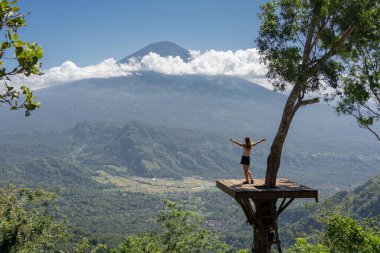 Genç bayan gezgin Bali adasında tatilin tadını çıkarın, Agung volkanı ile birlikte sahada durun..