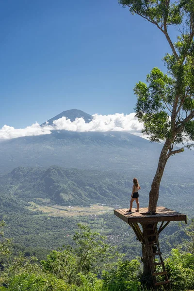 写真撮影スポットに立ちながら 山やアグン火山を眺めながら自然を楽しむ女性観光客 インドネシアのバリ 旅行のコンセプト — ストック写真