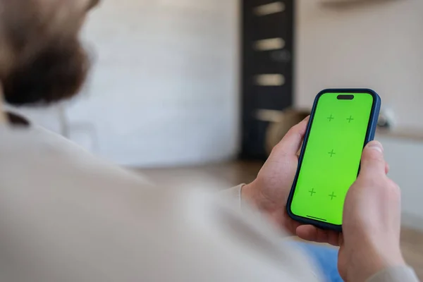 Uomo Casa Sdraiato Divano Utilizzando Smartphone Con Schermo Modello Verde — Foto Stock