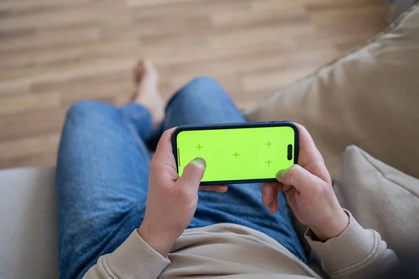 Evdeki Adam Kanepede Uzanmış Yeşil Model Ekranlı Akıllı Telefon Kullanıyor — Stok fotoğraf