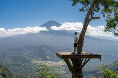 İnsan gezgin Bali adasında tatilin tadını çıkarır, Agung volkanı ile görüş açısında durur.