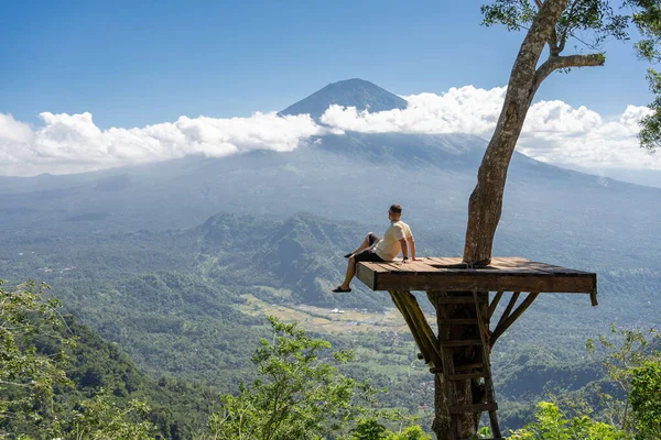 男旅行者はバリ島での休暇を楽しみアグン火山との視点に立つ — ストック写真
