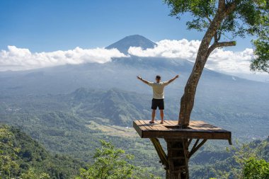İnsan gezgin Bali adasında tatilin tadını çıkarır, Agung volkanı ile görüş açısında durur.