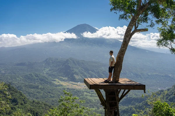 İnsan gezgin Bali adasında tatilin tadını çıkarır, Agung volkanı ile görüş açısında durur.