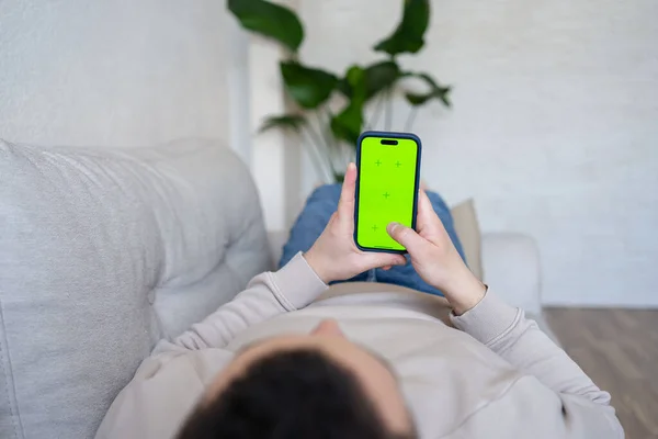 Hombre Casa Acostado Sofá Usando Teléfono Inteligente Con Pantalla Verde —  Fotos de Stock