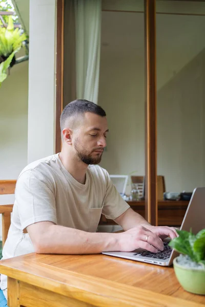 Young man using a laptop computer in a garden . business, study, freelance