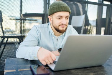  Dizüstü bilgisayarda çalışan genç bir adam. Teknoloji insanları konsept üzerinde çalışır. Adam kafede dizüstü bilgisayar kullanıyor.