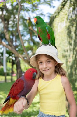 Endonezya 'da hayvanat bahçesinde omzunda papağan olan güzel bir kız çocuğu.. 