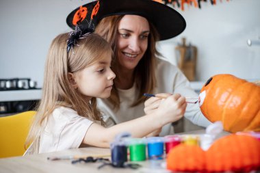 Anne ve küçük kız evde Cadılar Bayramı hazırlıkları sırasında oynuyorlar ve eğleniyorlar.. 