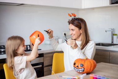 Anne ve küçük kız evde Cadılar Bayramı hazırlıkları sırasında oynuyorlar ve eğleniyorlar.. 