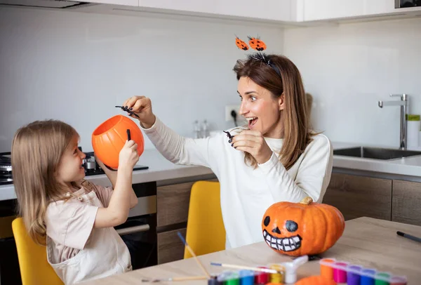 Anne ve küçük kız evde Cadılar Bayramı hazırlıkları sırasında oynuyorlar ve eğleniyorlar.. 