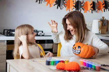 Anne ve küçük kız evde Cadılar Bayramı hazırlıkları sırasında oynuyorlar ve eğleniyorlar.. 