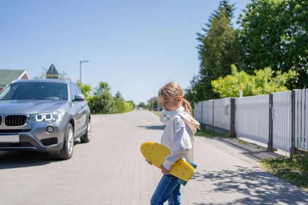 Meisje Met Skateboard Dat Weg Oversteekt Niet Naar Auto Kijkt — Stockfoto