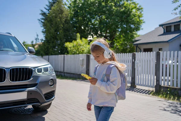 Mädchen Mit Kopfhörer Und Handy Überquert Straße Und Sieht Auto — Stockfoto