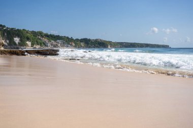 Kayalık dağları olan bir kumsal ve güneşli bir günde Hint okyanusunun berrak suları. . 